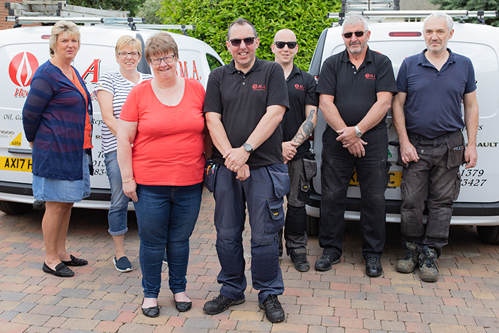 The MA Heating team standing in front of two company vans